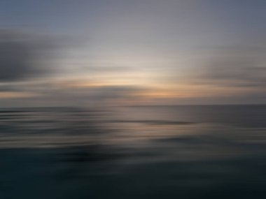 Okyanusta gün batımı bir bulanıklık içinde.