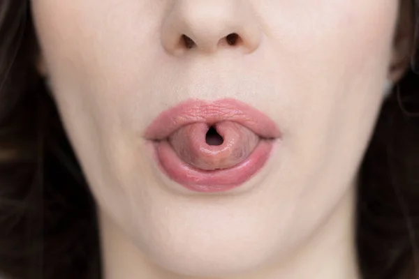 一个女人把她的舌头折叠在管子里 — 图库照片