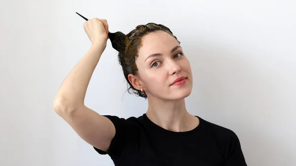 一个年轻的女人在头发上涂上草本混合的指甲油和玄武油 然后染成褐色 — 图库照片