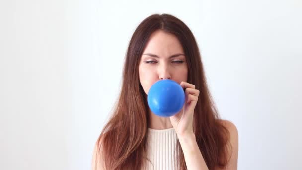 一个漂亮的女人给蓝色的气球充气 — 图库视频影像