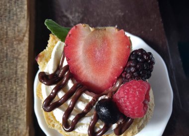 Lezzetli Moorkop. Koyu arkaplanda taze meyve soslu Hollanda böreği..