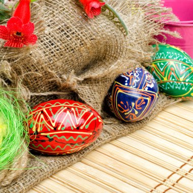 Easter composition. Painted Easter eggs and willow branches on a background of burlap.