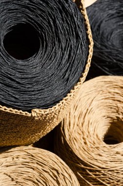 Raffia 'nın topları tahtaya yakın çekim yapıyor. Siyah ve bej rafya derileri örgü örmeye hazır..