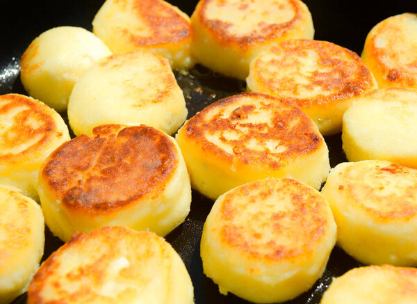 Cottage cheesecakes are fried in a frying pan. The process of cooking delicious homemade food. cheese pancakes or syrniki. close up