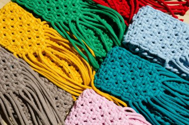 Makrome tekniğiyle örülmüş küçük el çantaları. Çok renkli cep telefonu çantaları.