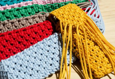 Makrome tekniğiyle örülmüş küçük el çantaları. Çok renkli cep telefonu çantaları.