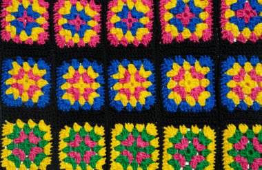 Renkli pamuklu büyükanne meydanı. Tığ işi dokusu, yakın plan fotoğraf. El yapımı zigzag takılar..