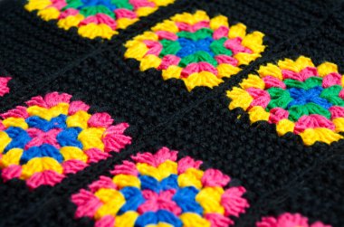 Renkli pamuklu büyükanne meydanı. Tığ işi dokusu, yakın plan fotoğraf. El yapımı zigzag takılar..