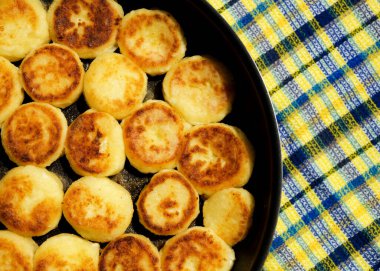 Ev yapımı peynirli kekler tavada kızartılır. Altın kabuklu lezzetli süzme peynirli krep..