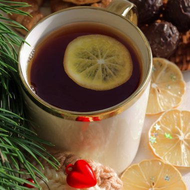 Sevgililer Günü için siyah çay ve limonlu güzel kupa. Kalpler, çikolatalı kurabiyeler ve kurutulmuş limon..