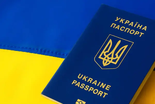 Ukrainian passport against the background of the Ukrainian flag. Immigration of people in connection with the war. Russian aggression against Ukraine.