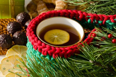 Limonlu çay. Çikolatalar, kurutulmuş limon ve Noel ağacı dalları. Tatil kartı.