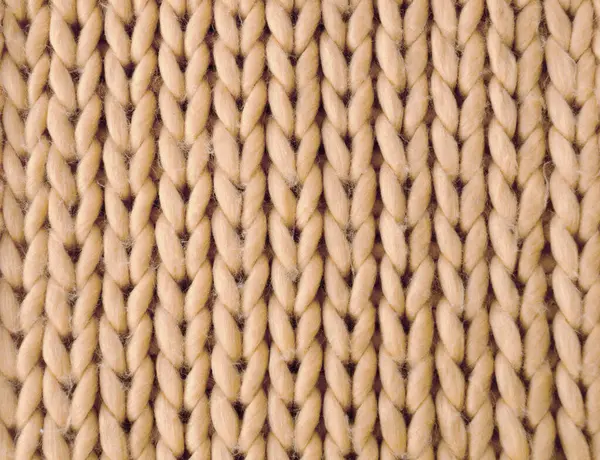 Knitting, sample from beige yarn. Synthetic fibers, three-dimensional pattern.