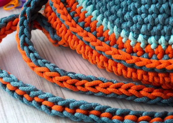 Cotton yarn. Cotton cord pattern in turquoise and orange. A fragment of a women\'s handbag made from ECO yarn
