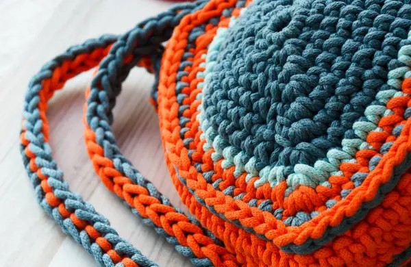 Cotton yarn. Cotton cord pattern in turquoise and orange. A fragment of a women\'s handbag made from ECO yarn