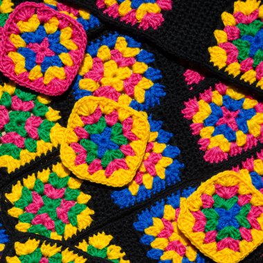 Renkli pamuklu büyükanne meydanı. Tığ işi dokusu, yakın plan fotoğraf. El yapımı zigzag takılar..