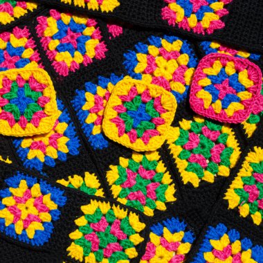 Renkli pamuklu büyükanne meydanı. Tığ işi dokusu, yakın plan fotoğraf. El yapımı zigzag takılar..