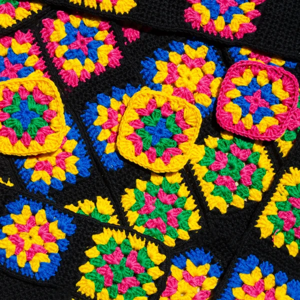 Renkli pamuklu büyükanne meydanı. Tığ işi dokusu, yakın plan fotoğraf. El yapımı zigzag takılar..