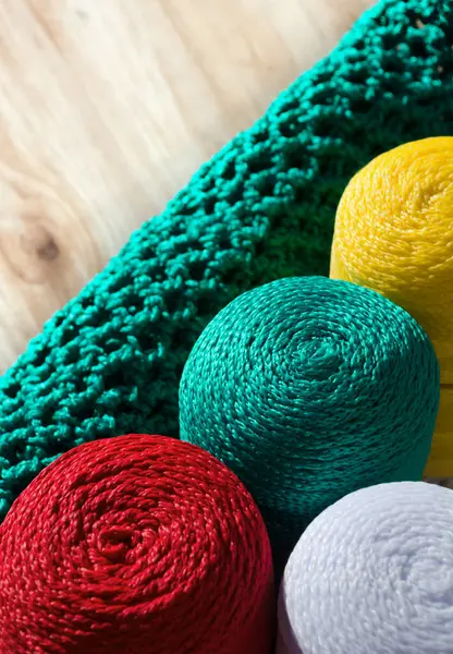 Polyester cords in rolls on a wooden background. Multi-colored cords for knitting bags and baskets.