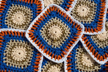 Renkli pamuklu büyükanne meydanı. Tığ işi dokusu, yakın plan fotoğraf. El yapımı zigzag takılar..