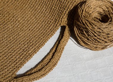 Bir raffia çantası örüyorum. Raffia örgü dokusu, kraft renkleri. Tığ işi çantalar, debriyaj, şapkalar, cüzdanlar. El yapımı iş için eko materyal