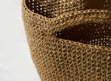 Kadın mafyası çantasına yakın çekim. Raffia örgü dokusu, kraft renkleri. Tığ işi çantalar, pençeler. El yapımı iş için eko materyal.