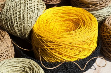 Raffia topları arka planda bir çuval bezine yakın çekim yapıyor. Raffia Skeins örgü örmeye hazır..