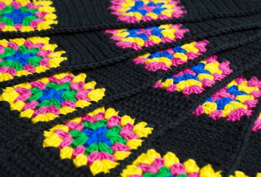 Renkli pamuklu büyükanne meydanı. Tığ işi dokusu, yakın plan fotoğraf. El yapımı zigzag takılar..