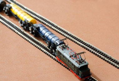 Yakıt tanklarının patlaması. Seçici odak etkisi olan oyuncak demiryolu. Karanlık arka planda bir lokomotif modeli. Demiryolu ve trenler.