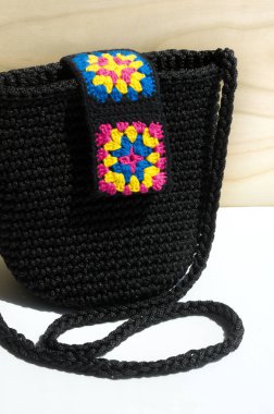 Women's black bag made of polyester cord. Small bag with elements of the Granny square pattern. clipart