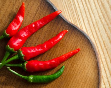 Kesme tahtasında acı biber. Kırmızı ve yeşil biber kabuklarına yakın çekim