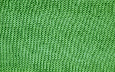 Detaylı bir makro çekim yeşil örgü kumaşı gösteriyor. Dikey düz V şeklinde desenli borsa dikişi yumuşak, düz ve dokulu bir yüzey oluşturur. El örgüsü..