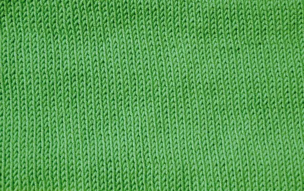 Detaylı bir makro çekim yeşil örgü kumaşı gösteriyor. Dikey düz V şeklinde desenli borsa dikişi yumuşak, düz ve dokulu bir yüzey oluşturur. El örgüsü..