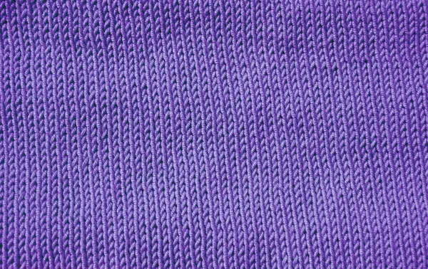 Detaylı bir makro çekim mor örgü kumaşı gösteriyor. Dikey düz V şeklinde desenli borsa dikişi yumuşak, düz ve dokulu bir yüzey oluşturur. El örgüsü..