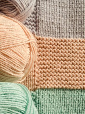 Şeftali rengi, nane yeşili ve lavanta rengi üç yumuşak iplik yumağı örgü kumaşın renklerini yansıtıyor. Her biri farklı bir dikiş deseni gösteriyor..