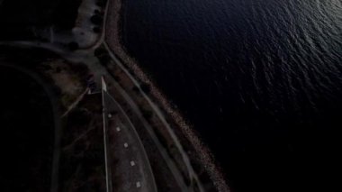 Kuşların Gözü, kıyı şeridinin yukarıdan görünüşü, açık mavi denizin ve araba trafiğiyle köprünün görüntüsünü ortaya çıkarıyor. Arka planda açık deniz rüzgârının gücüyle gün batımı. Havadan aşağıya doğru eğil. Limhamn İsveç ile Danimarka arasında bir köprü.