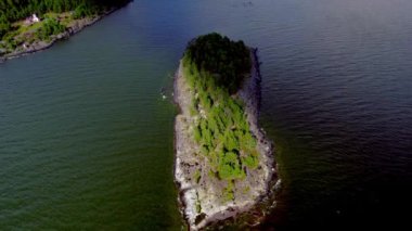 Clouds cast shadow over islet in lake. Revealing shot of island and vast forest in Lake Vanern in Saffle Varmland Sweden