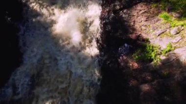 Top down view above raging river. Straight down on rapids with rocky bank. Close up in Ambjorby Famtfallet Varmland Sweden