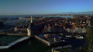 Dolly shot of Dutch Historic old inner harbor and lock with harbourmaster's office of the city of Hoorn, moored sailboats at the quay. In North Holland, Netherlands Markermeer. Close-up aerial view