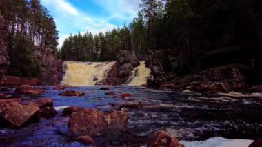 Low angle view, static shot of the beautiful waterfall Brattfallet in the forests of Sweden. With sound of high speed flowing water. In 59.94 fps for slow motion