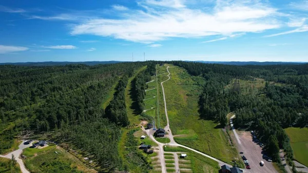 High angle view of a toboggan run, bobsleigh run in summer and ski slope in winter piste. Blue sky sunny day in summer Rattvik, Dalarna, Sweden