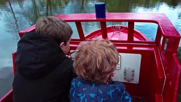 Παιδιά Ταξιδεύουν Μια Βάρκα Στη Λίμνη Αγόρι Οδηγεί Τιμόνι Παιδί — Αρχείο Βίντεο