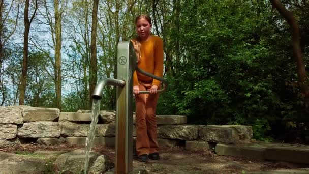 Εννιάχρονο Καυκάσιο Κορίτσι Αντλεί Νερό Μια Αντλία Νερού Ένα Πάρκο — Αρχείο Βίντεο
