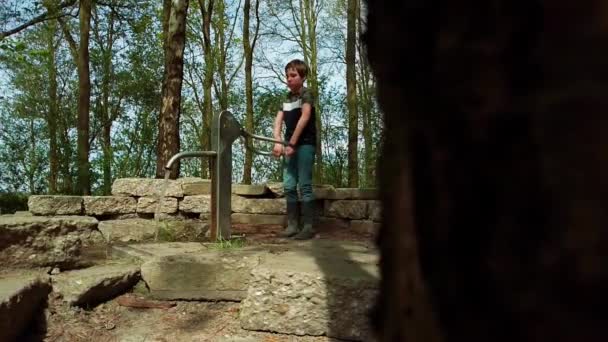 Ein Neunjähriger Junge Der Frühlingstag Einem Park Mit Der Wasserpumpe — Stockvideo