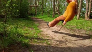 At kuyruklu bir kız parktaki halatla kayıyor. 9 yaşındaki beyaz çocuk, oyun alanında oynuyor. Açık hava konsepti, yavaş çekim statik çekim..
