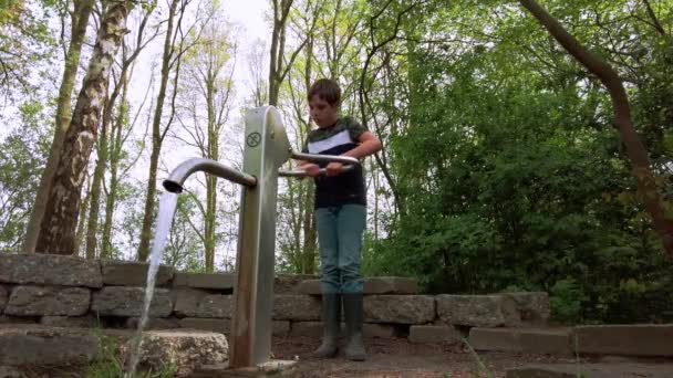 Een Jongen Van Negen Die Met Waterpomp Speelt Een Park — Stockvideo