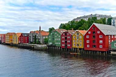 İskandinav liman kenti Trondheim Norveç 'te, Brygge bölgesindeki Nidelva nehri üzerinde renkli cepheli tarihi ahşap binalar ve evler.