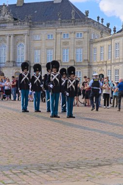 Kraliyet can kurtaran birlikleri hazır olda beklesin ve görev yerindeki nöbetçileri görevden alsın. Danimarka 'da Kopenhag' daki Amalienborg Sarayı 'nda muhafızların değişimi.