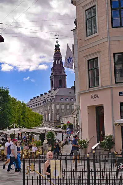 アマガルトルフ広場の歩行者通りを歩く観光客や買い物客の景色は テラスや食堂のカフェを通り過ぎました 背景にはキリスト教徒の宮殿の塔があります コペンハーゲンデンマーク 2023 — ストック写真