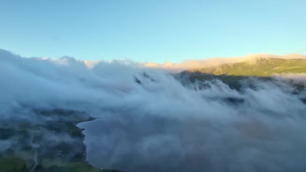 空からの眺め 雲の上を飛ぶ無人機 山の湖の海岸 夏の太陽の青い空によって照らされる緑の山の尾 美しいノルウェーの自然景観のバードの視点 — ストック動画